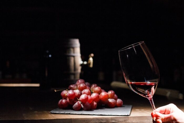 vino con uvas en el fondo